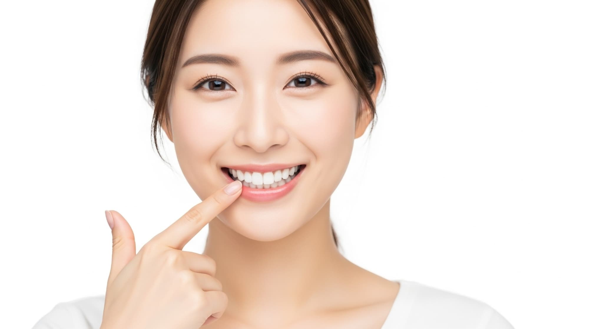 ブリッジで治療した歯を指さす女性