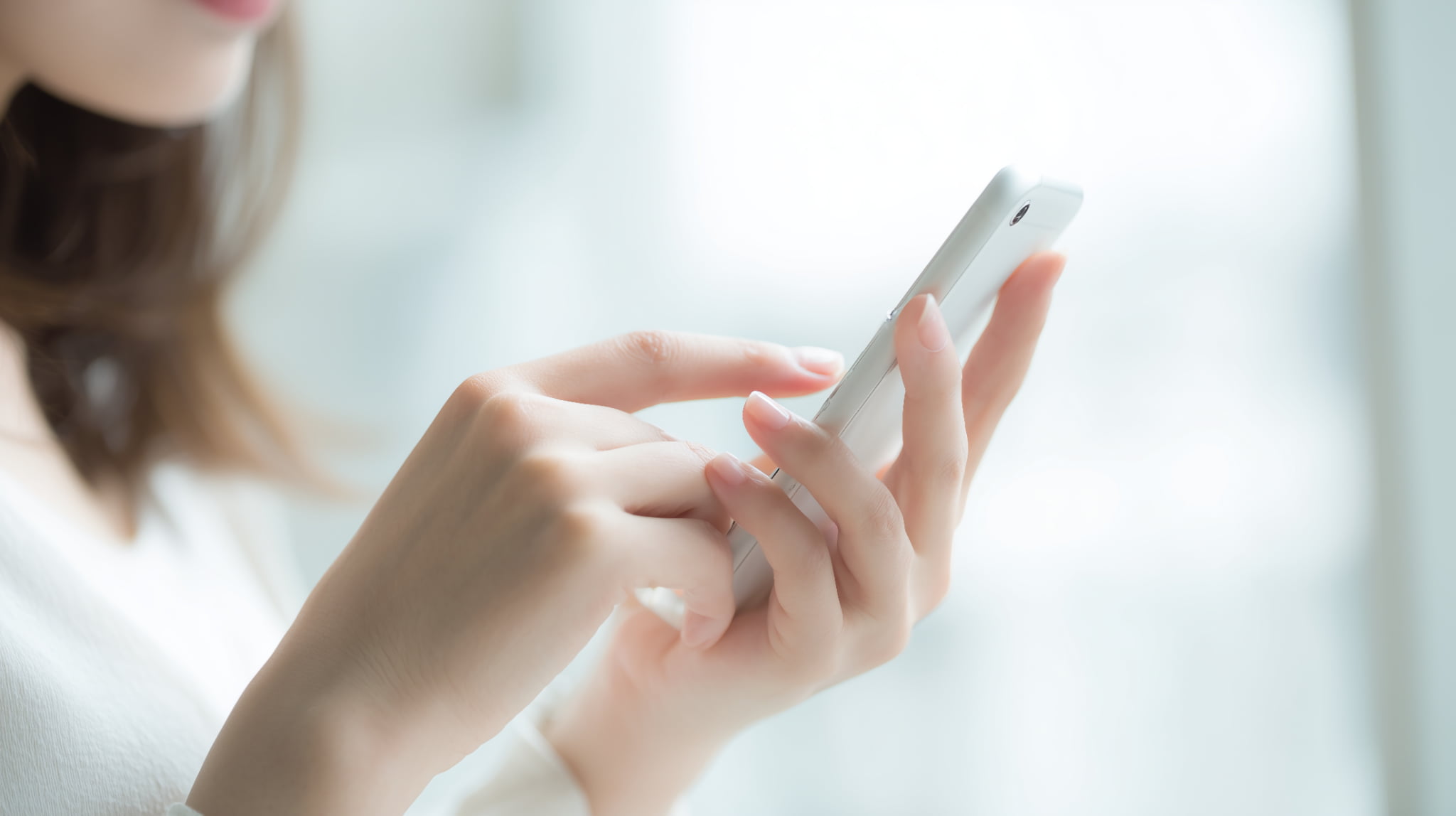 スマートフォンで装着時間の管理を行う女性