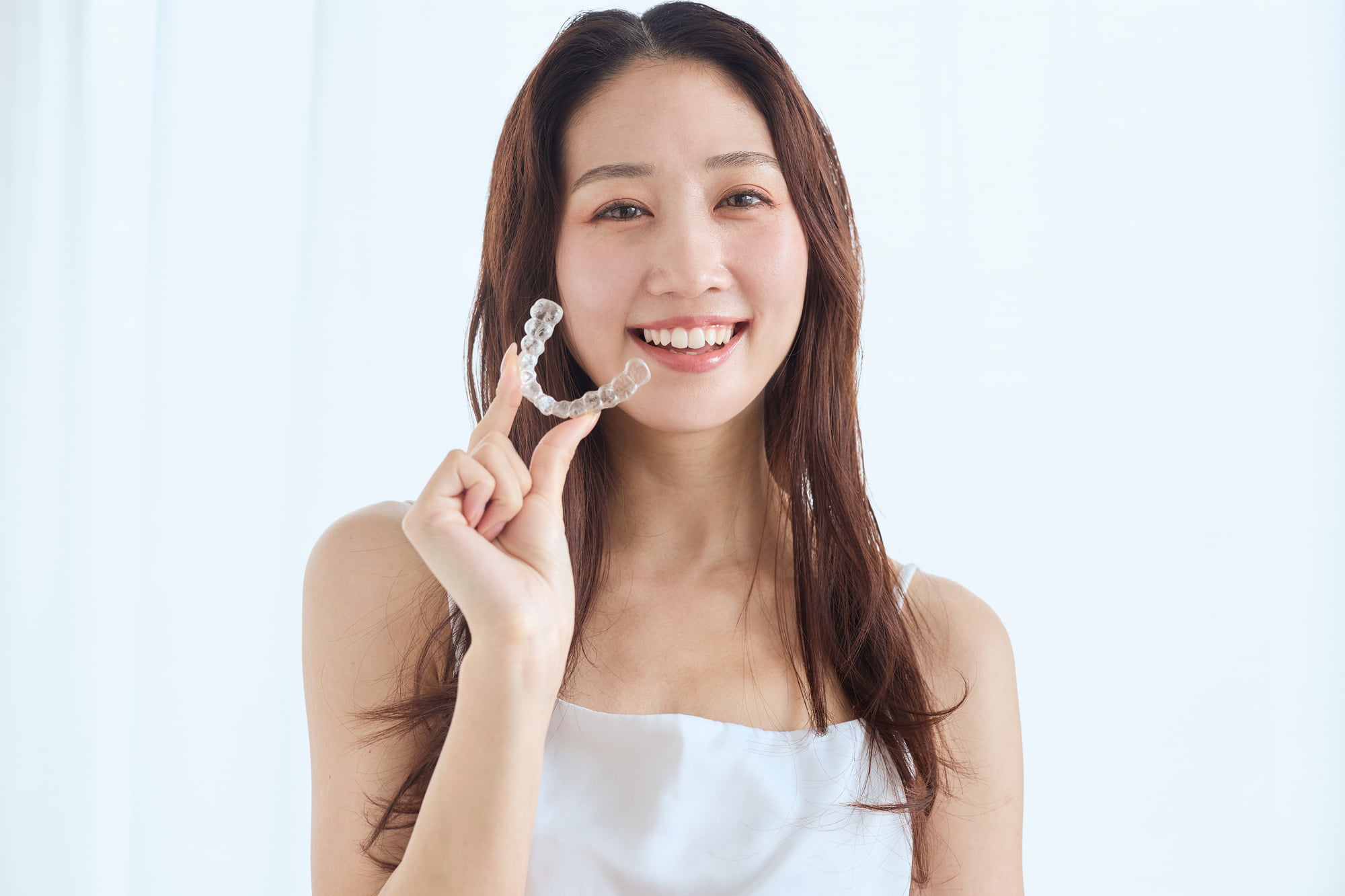 マウスピース矯正を続ける笑顔の女性
