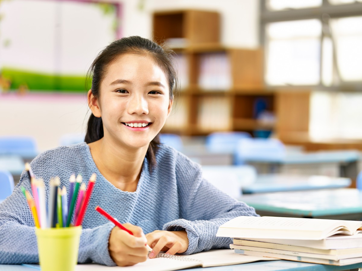 適切なケアで健康な歯ぐきの子どもが笑顔で勉強をしているイメージ